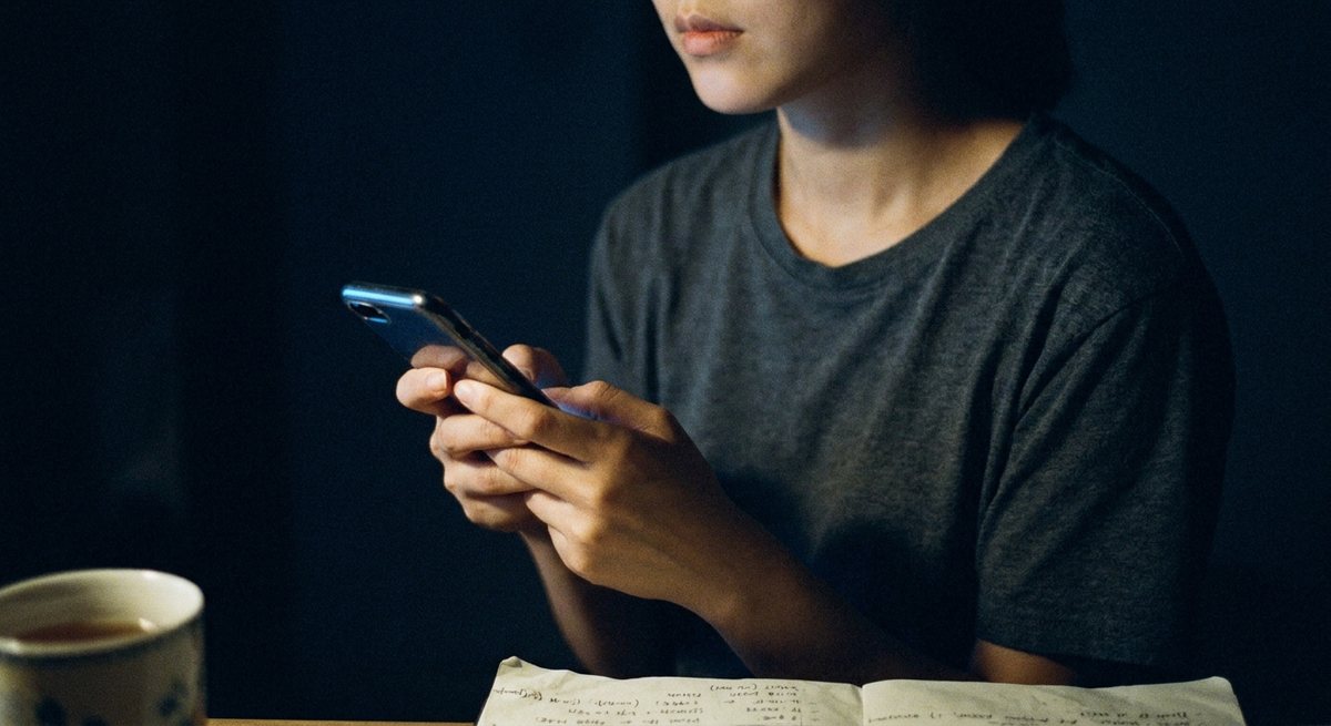 어두운 방에서 혼자 폰 화면을 들여다보는 사람 — 혼자 확인하고 혼자 실망하는 밤